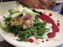 Arugula with Israeli couscous, goat cheese, lemon cucumber, and a blackberry yogurt dressing.