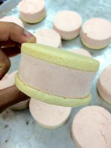 Strawberry ice cream between two vanilla shortbread cookies.